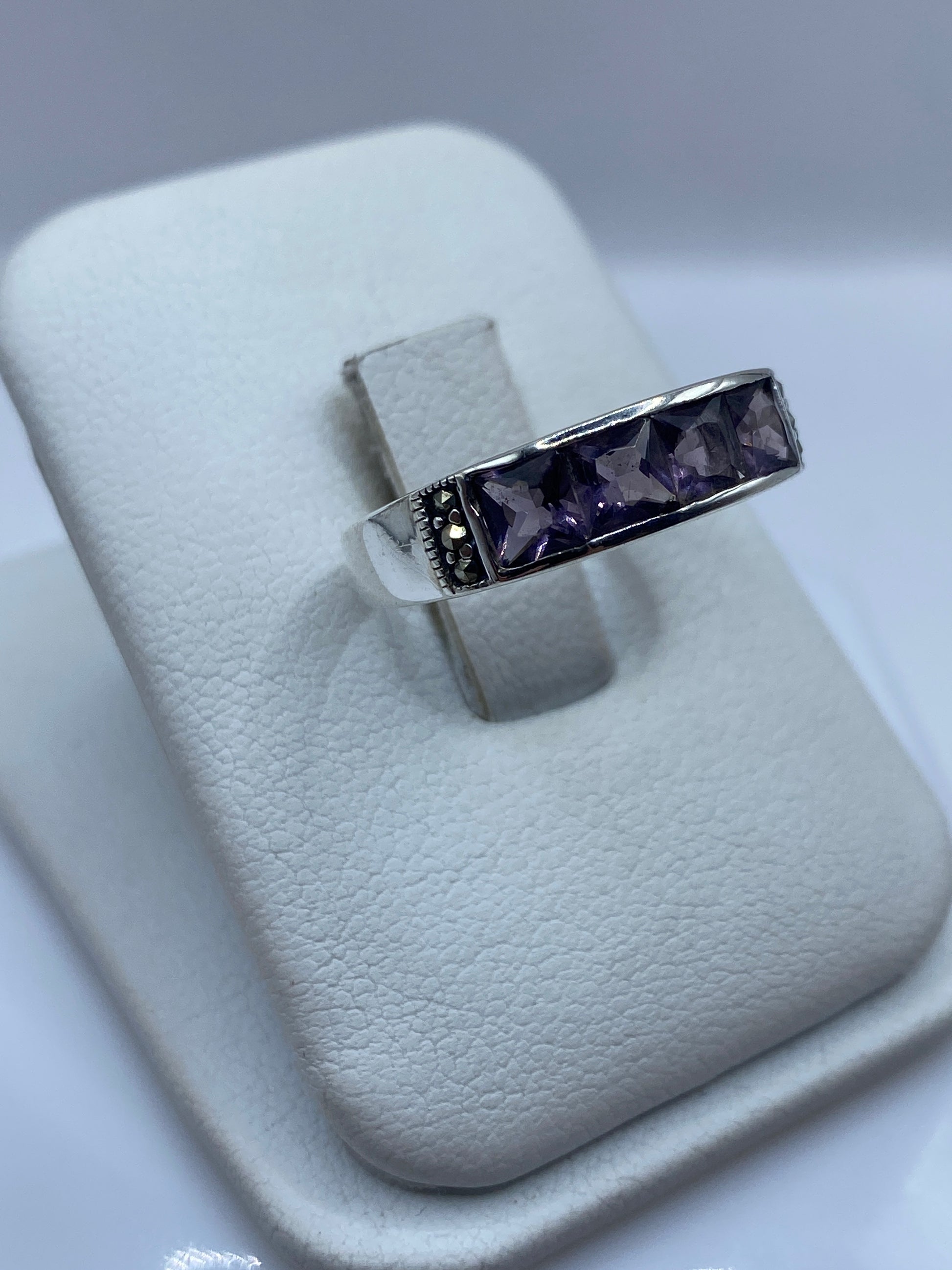 Anillo de plata .925 con piedra facetada, detalle lateral mostrando la ornamentación