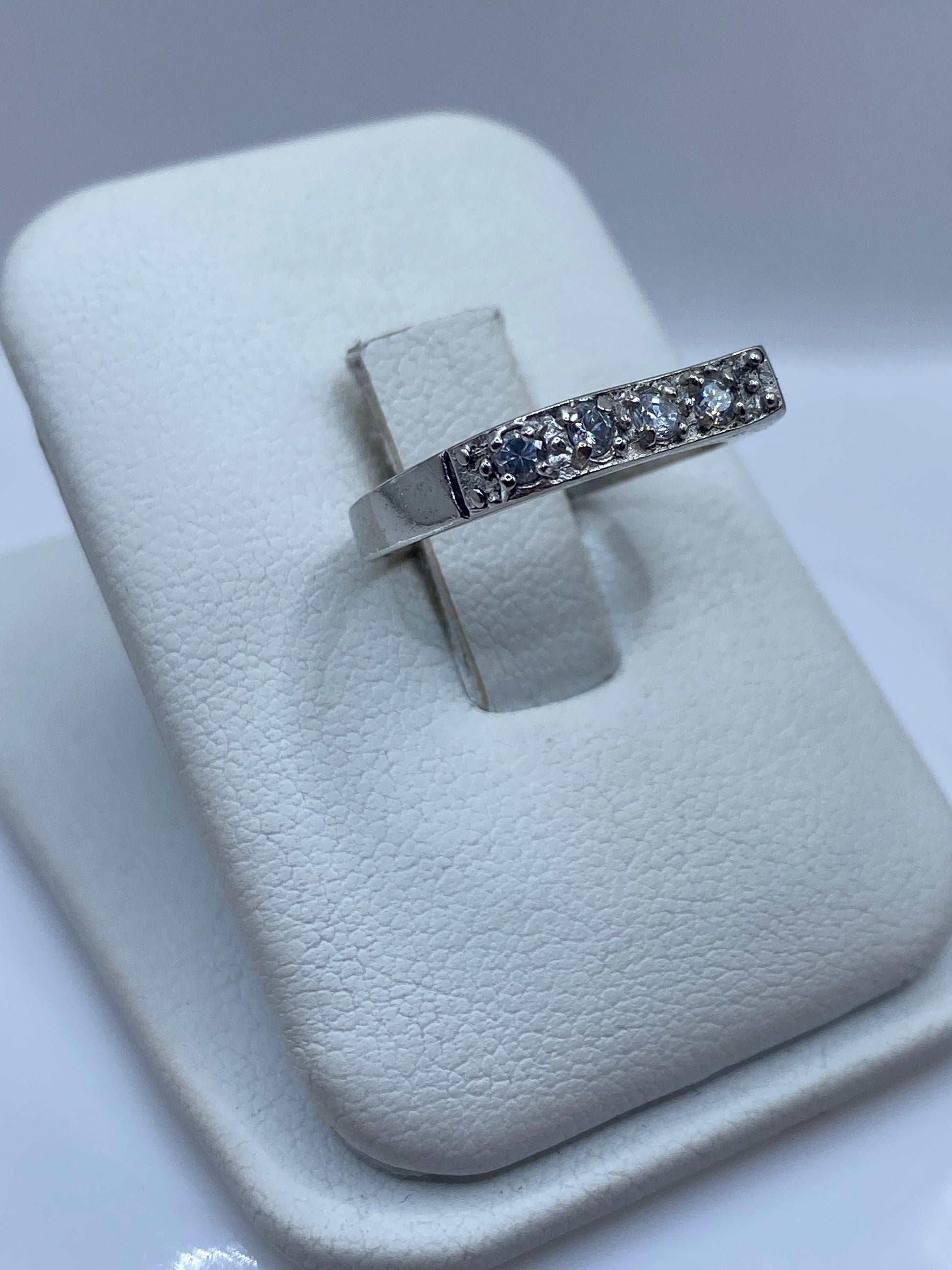 Vista frontal del anillo minimalista .925 con piedra blanca en línea horizontal