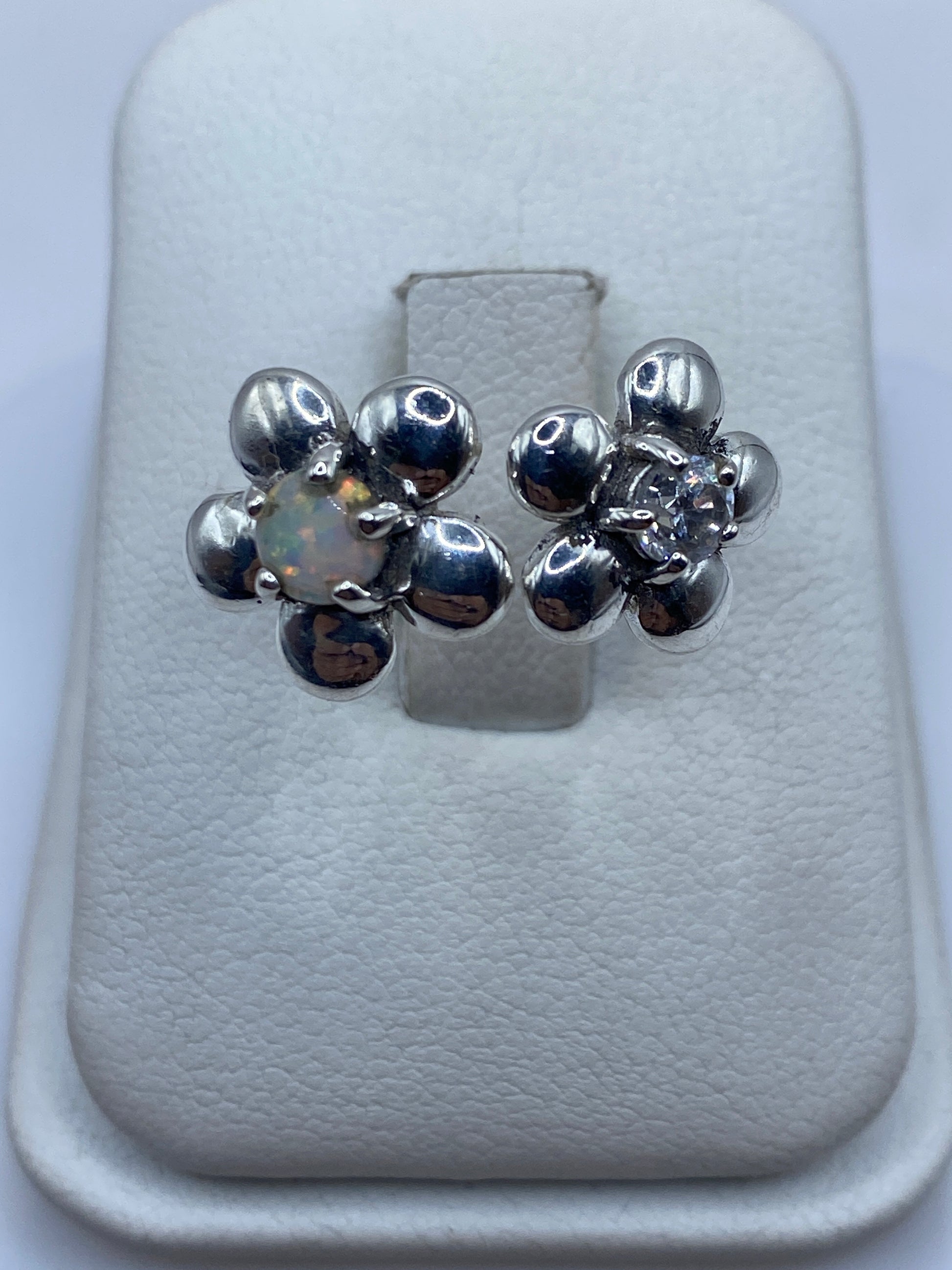Anillo de plata ajustable con ópalo de fuego multicolor en la mano de una mujer