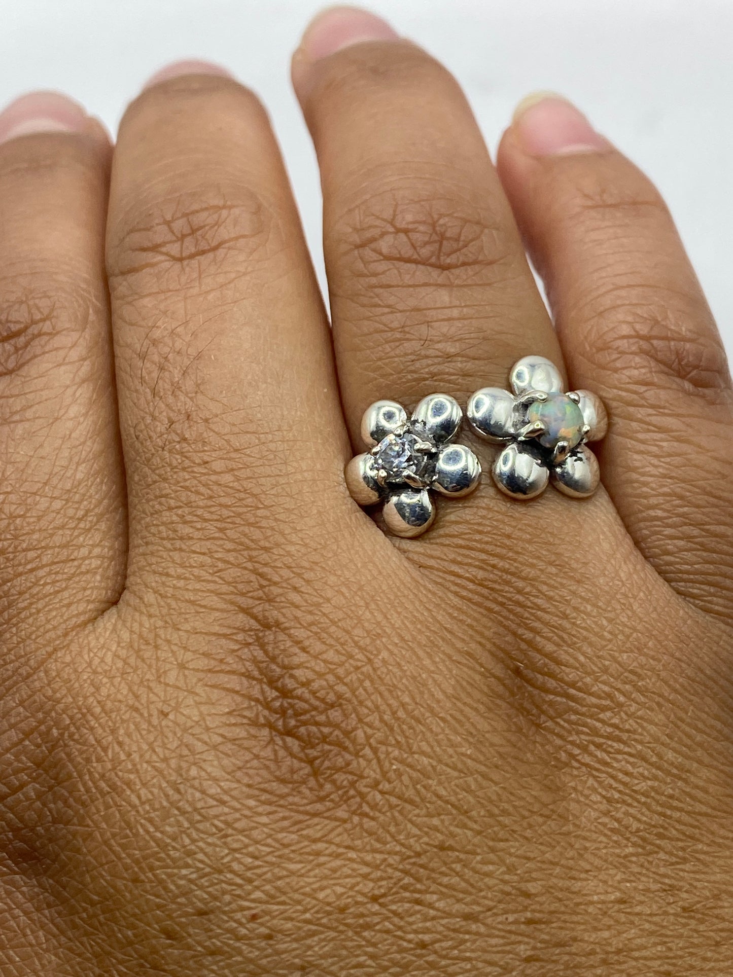 Anillo de ópalo sobre fondo gris mostrando la iridiscencia natural de la piedra