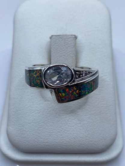 Anillo de plata con ópalo de fuego multicolor mostrando juego de colores amarillo, rojo y verde