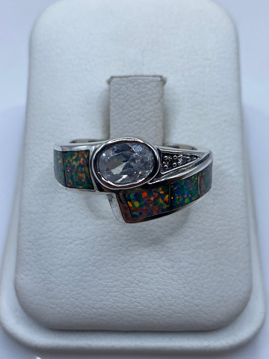 Anillo de plata con ópalo de fuego multicolor mostrando juego de colores amarillo, rojo y verde
