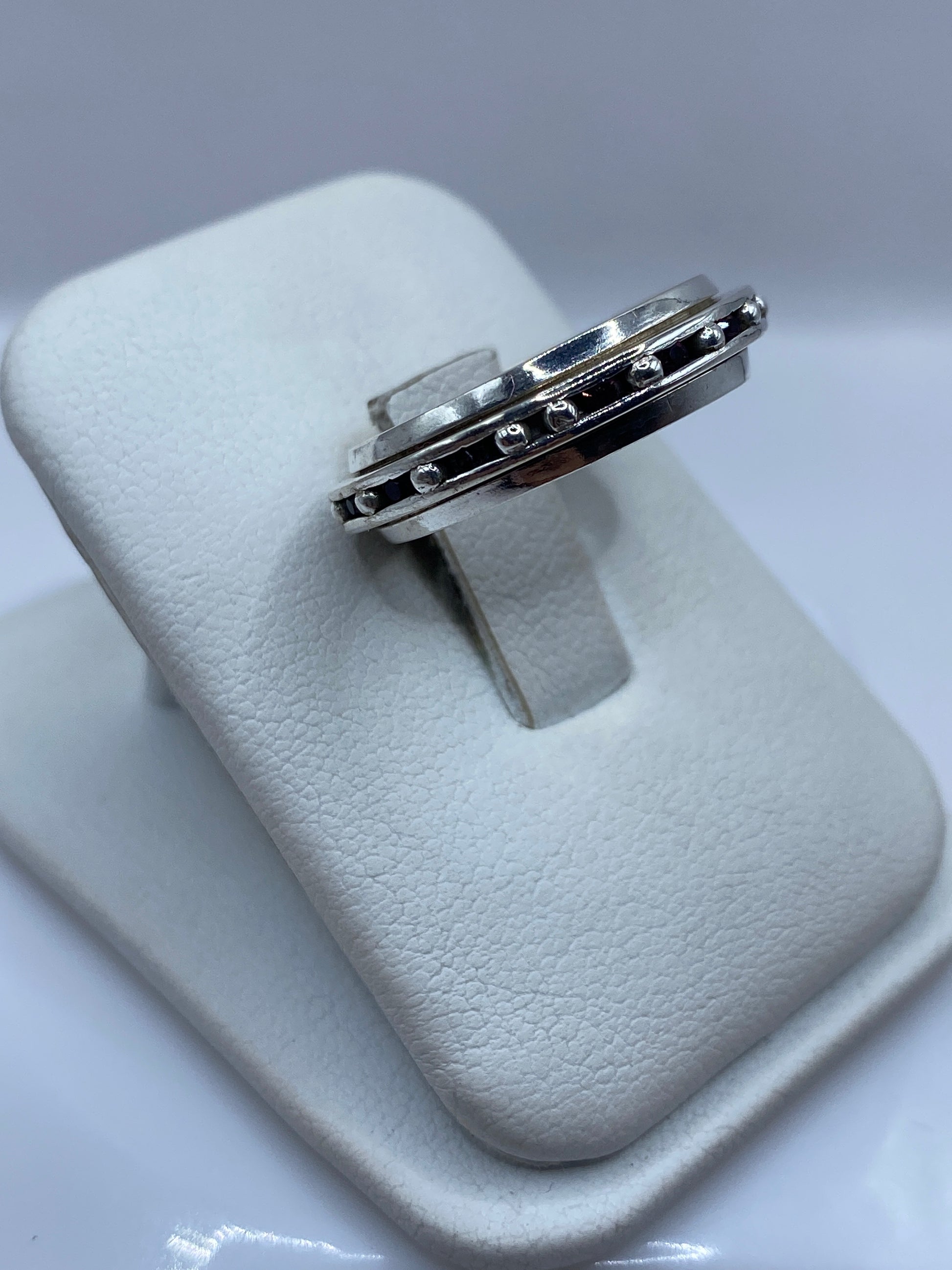 Detalle lateral del anillo giratorio mostrando las dos bandas de plata y circonia rosa en movimiento