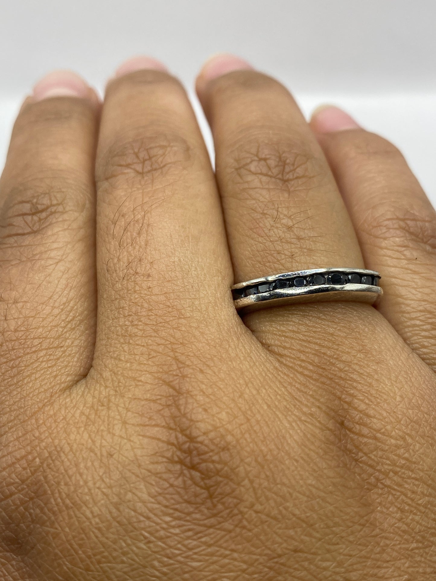 Anillo en la mano mostrando el contraste entre plata y piedra negra