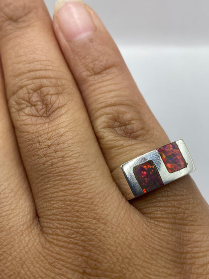 Anillo ópalo de fuego sobre fondo neutro, luz natural revelando el brillo cambiante de la piedra