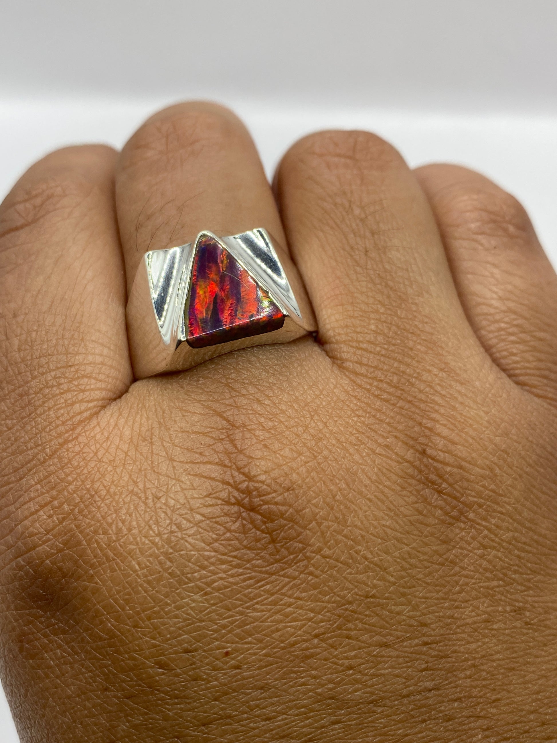 Anillo en dedo masculino mostrando el diseño moderno y el juego de luz del ópalo