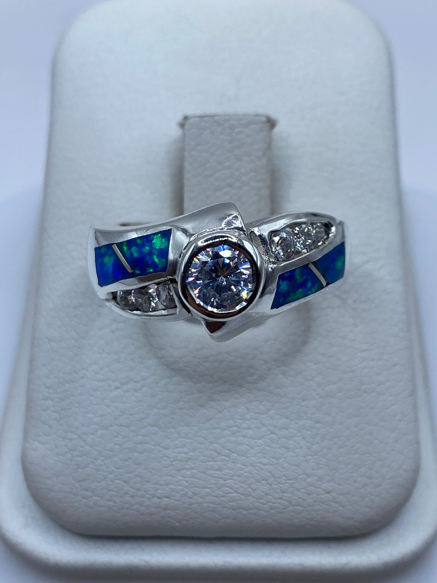 Anillo de plata .925 con ópalo de fuego azul y circonias blancas, vista frontal en estuche blanco