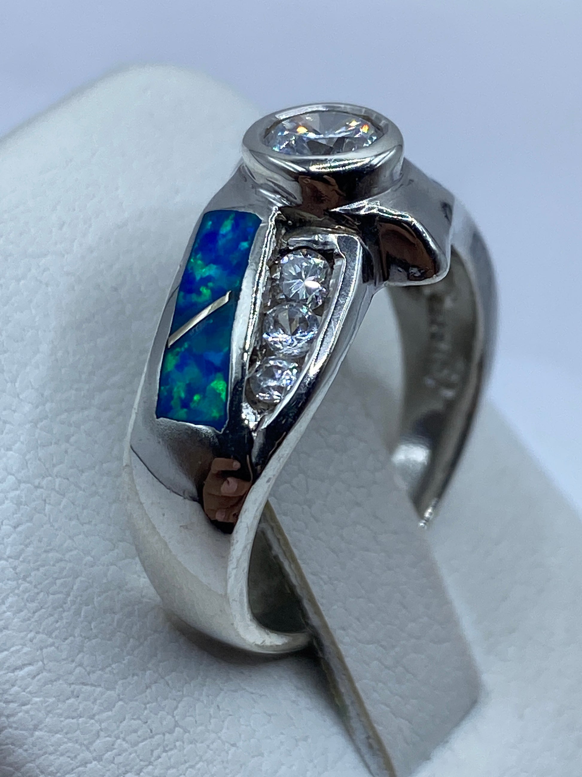 Anillo de plata moderno con ópalo azul en dedo, mostrando el brillo de la piedra