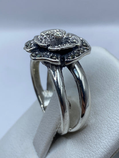 Detalle de los pétalos texturizados del anillo en la mano de una mujer