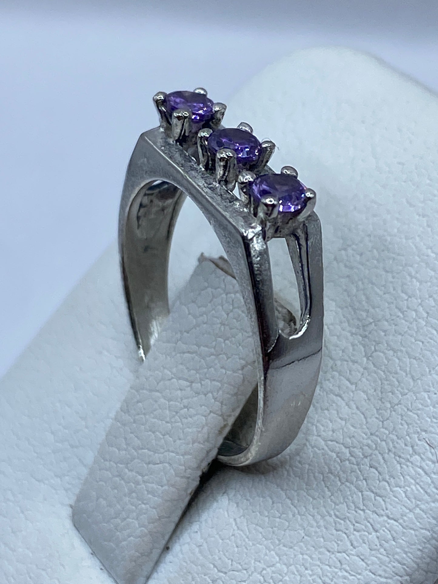 Anillo de plata con circonia morada en mano, demostrando tamaño y elegancia minimalista