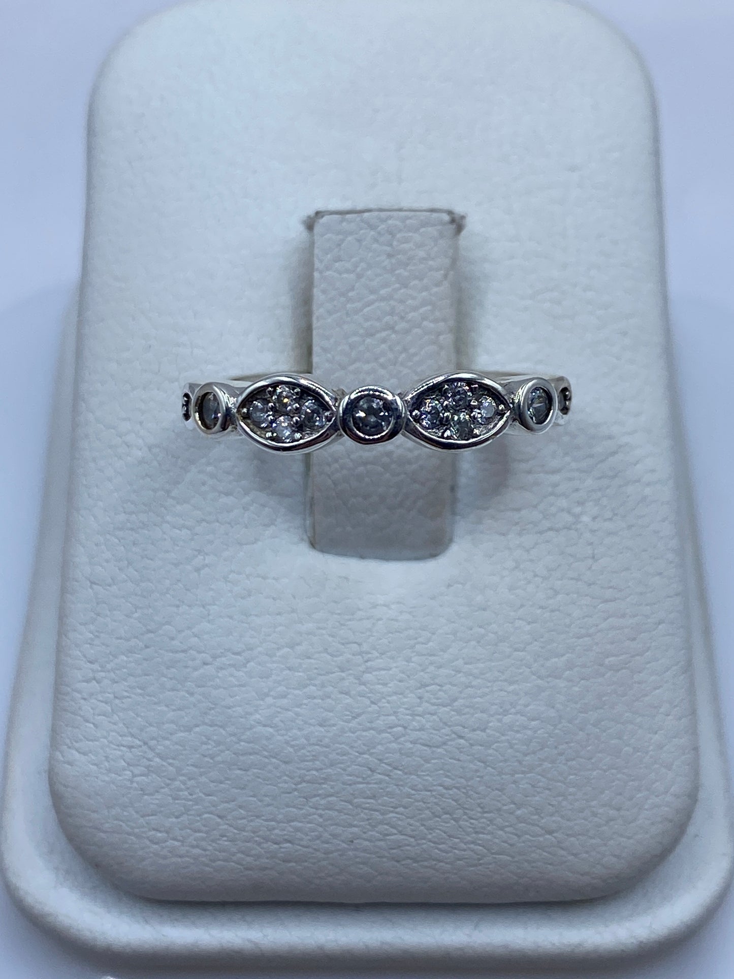 Anillo de plata con línea de circonias blancas en la mano de una mujer