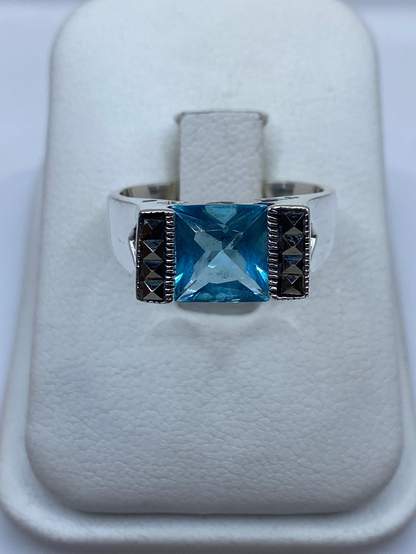 Anillo solitario de plata con circonia azul cielo en presentación de caja blanca