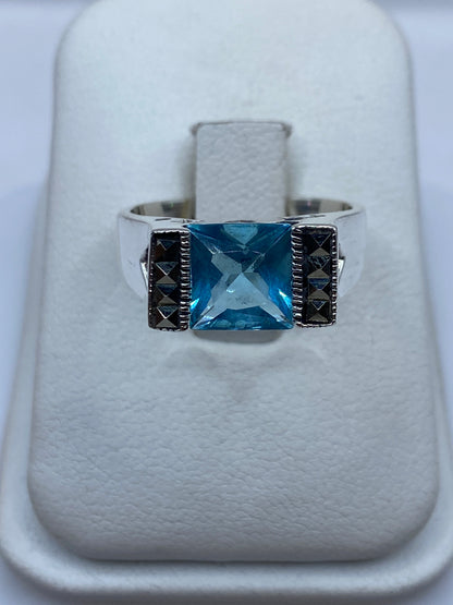 Anillo solitario de plata con circonia azul cielo en presentación de caja blanca