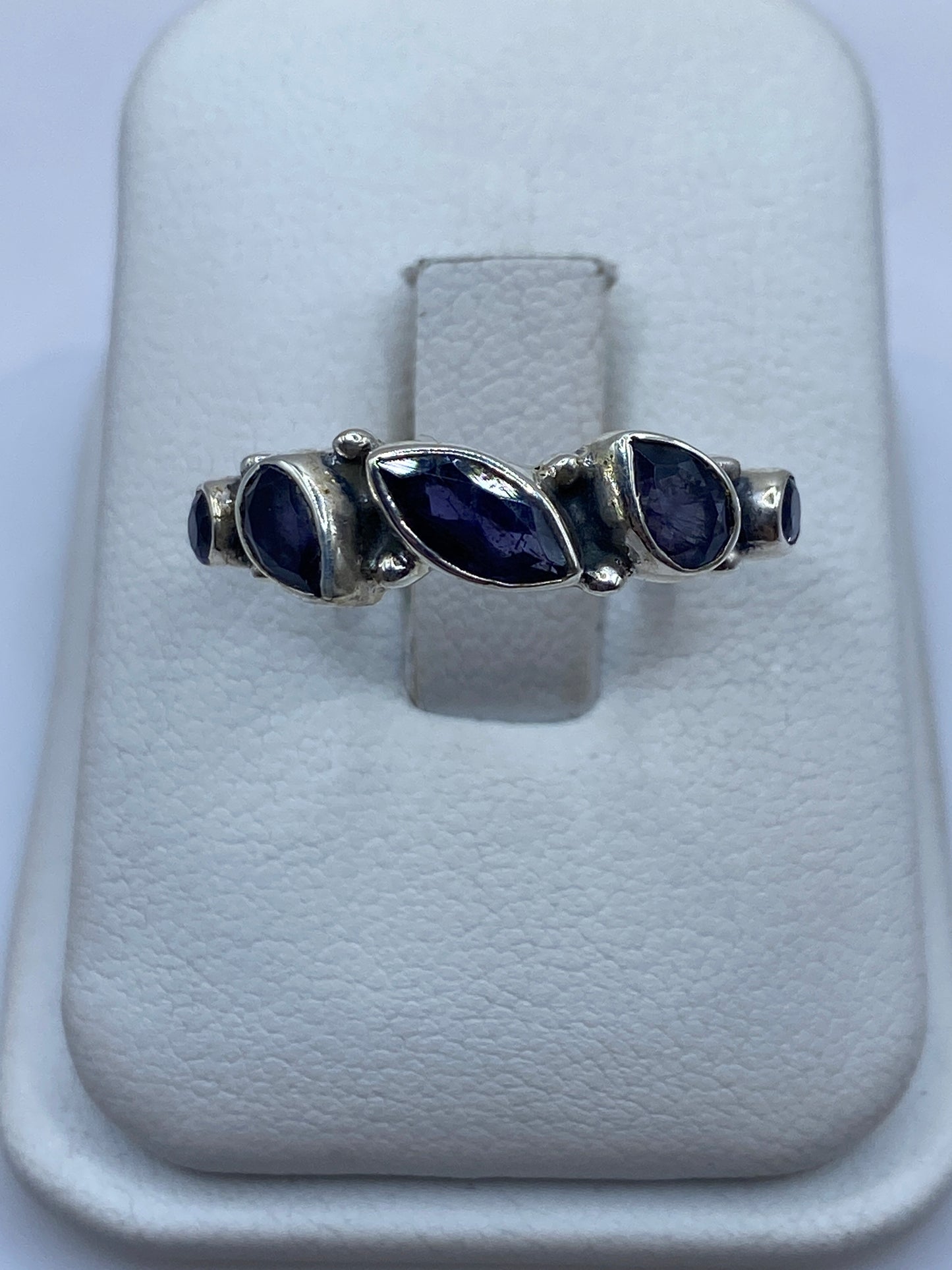 Anillo de plata solitario con circonia azul en la mano de una mujer