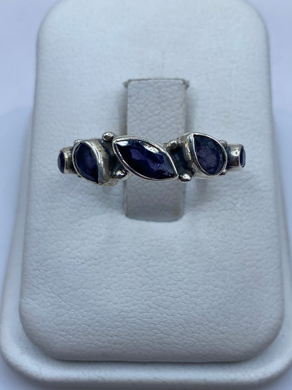 Anillo de plata solitario con circonia azul en la mano de una mujer