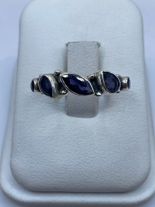 Anillo de plata solitario con circonia azul en la mano de una mujer