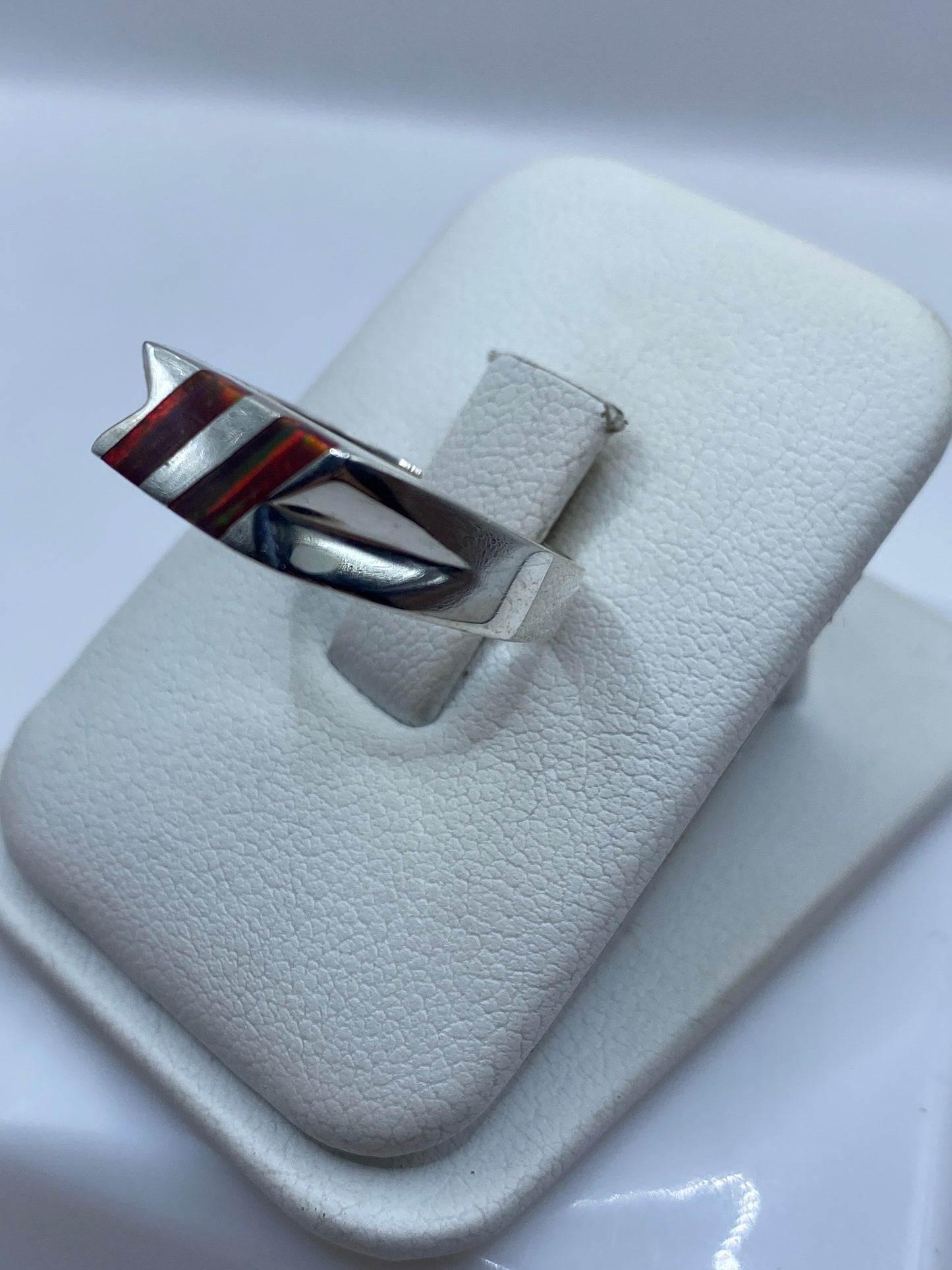 Vista lateral del anillo unisex de plata y ópalo sobre fondo blanco