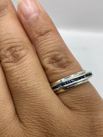 Anillo solitario en la mano mostrando el brillo azul intenso de la piedra