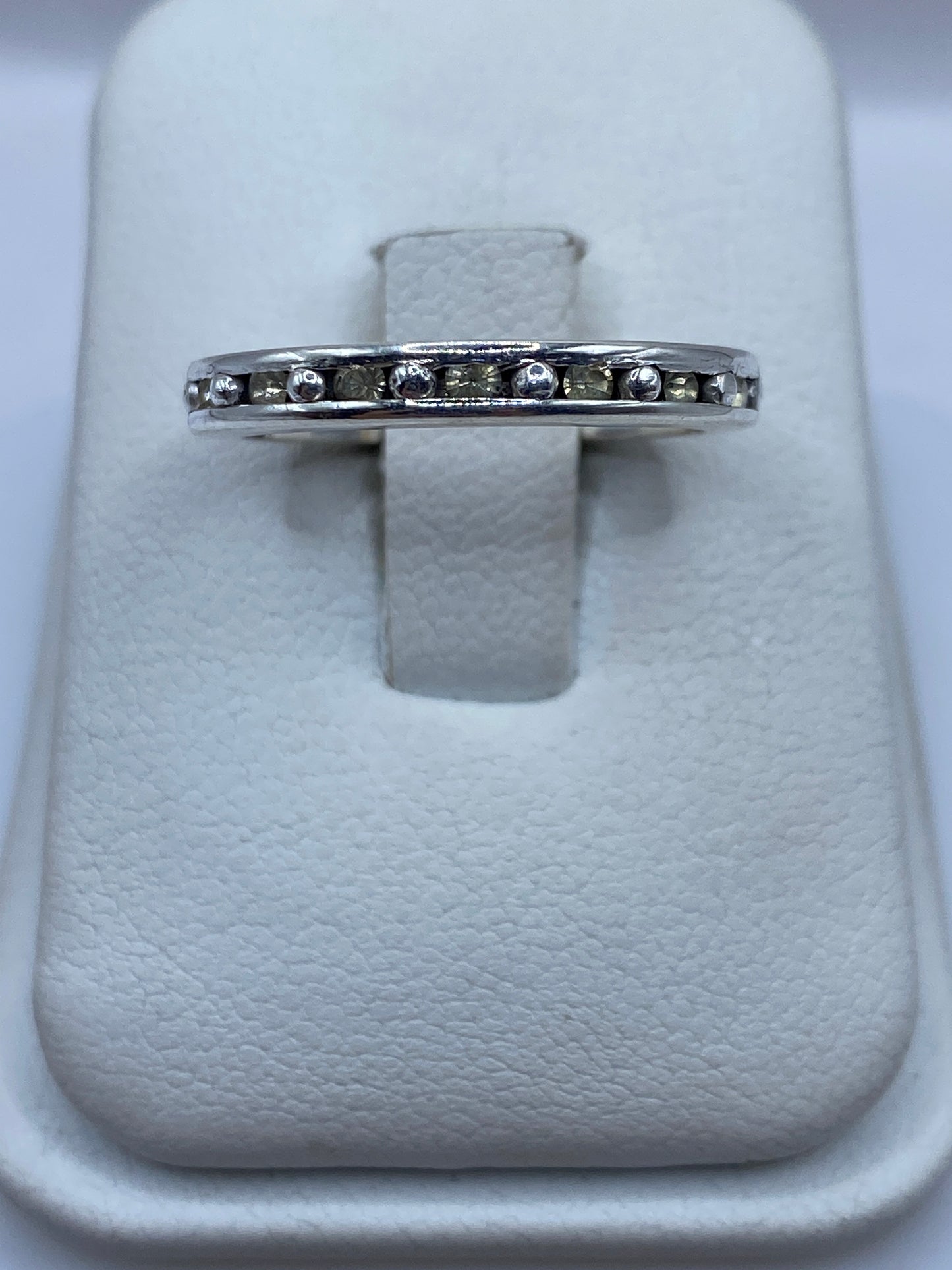 Anillo de plata eslabón con circonia amarilla en la mano de una mujer