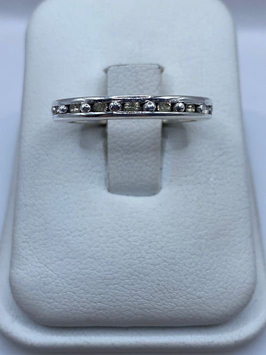 Anillo de plata eslabón con circonia amarilla en la mano de una mujer
