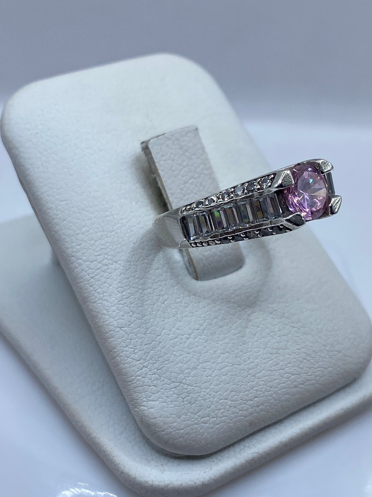 Vista frontal del anillo mostrando la circonia rosa facetada y los flancos de plata trabajada
