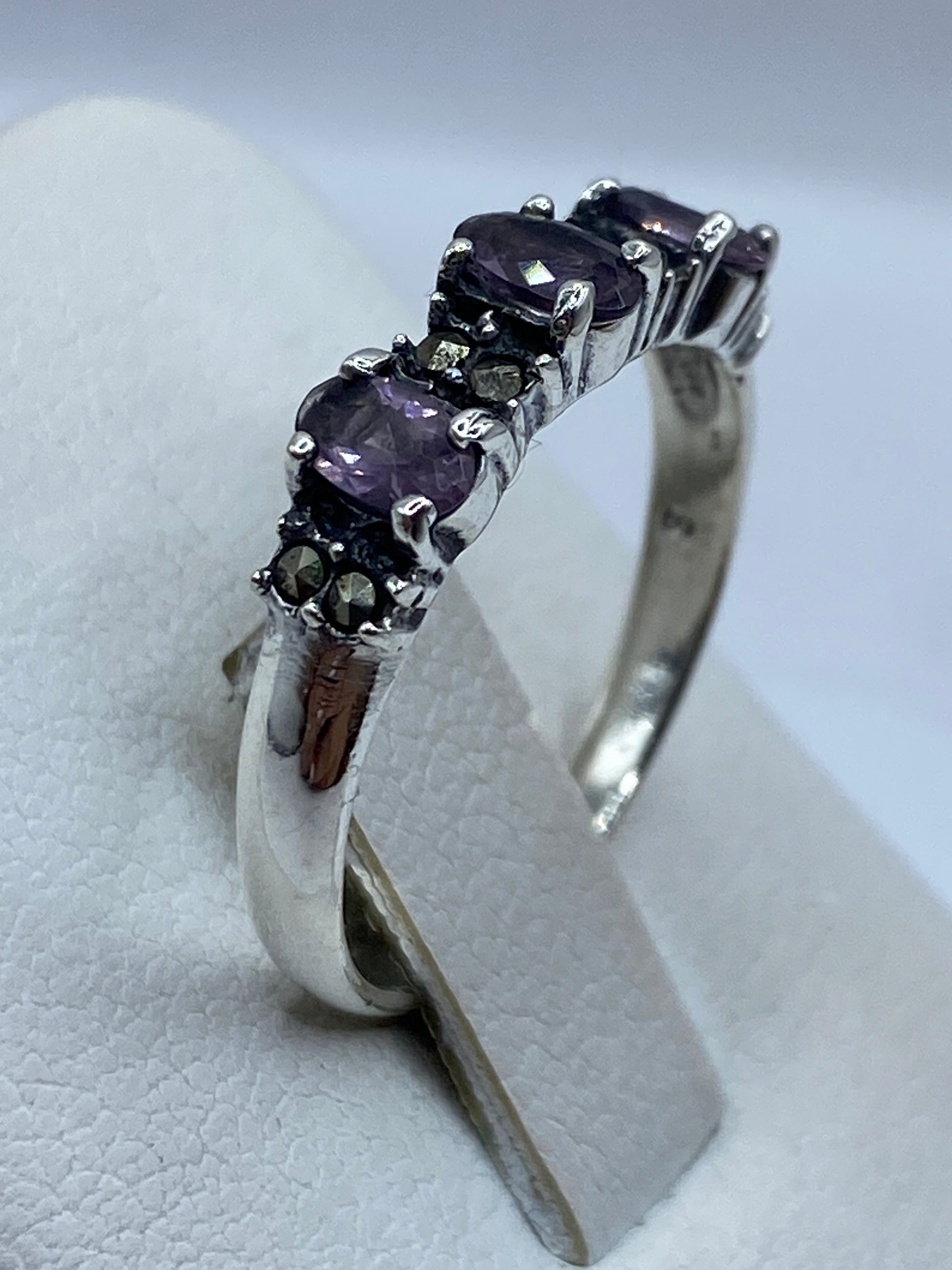 Detalle lateral del anillo mostrando facetas de circonia morada