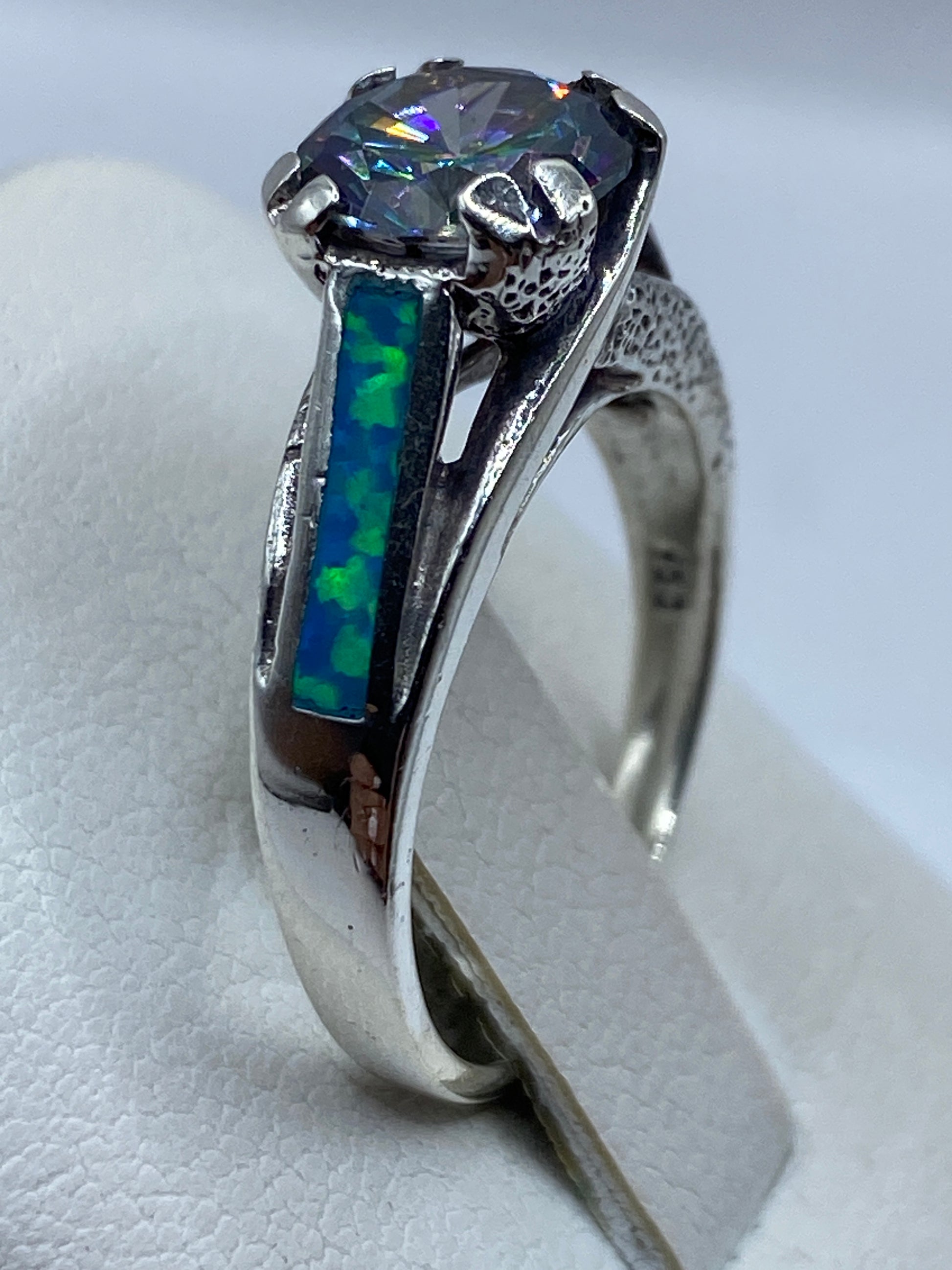 Detalle del ópalo azul con fuego y reflejos, portado en mano
