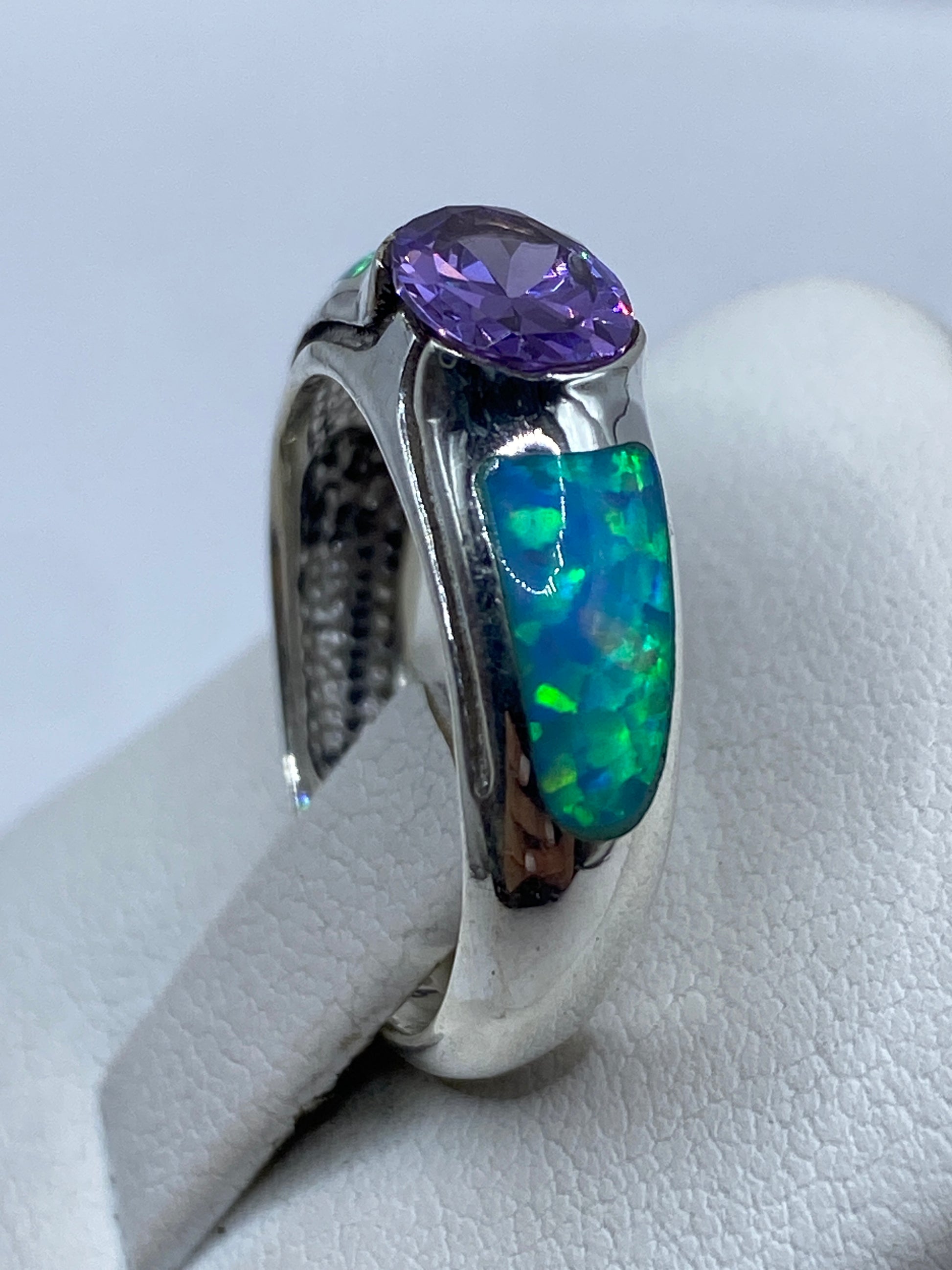Detalle lateral del anillo mostrando el acabado pulido espejo y la profundidad del ópalo azul