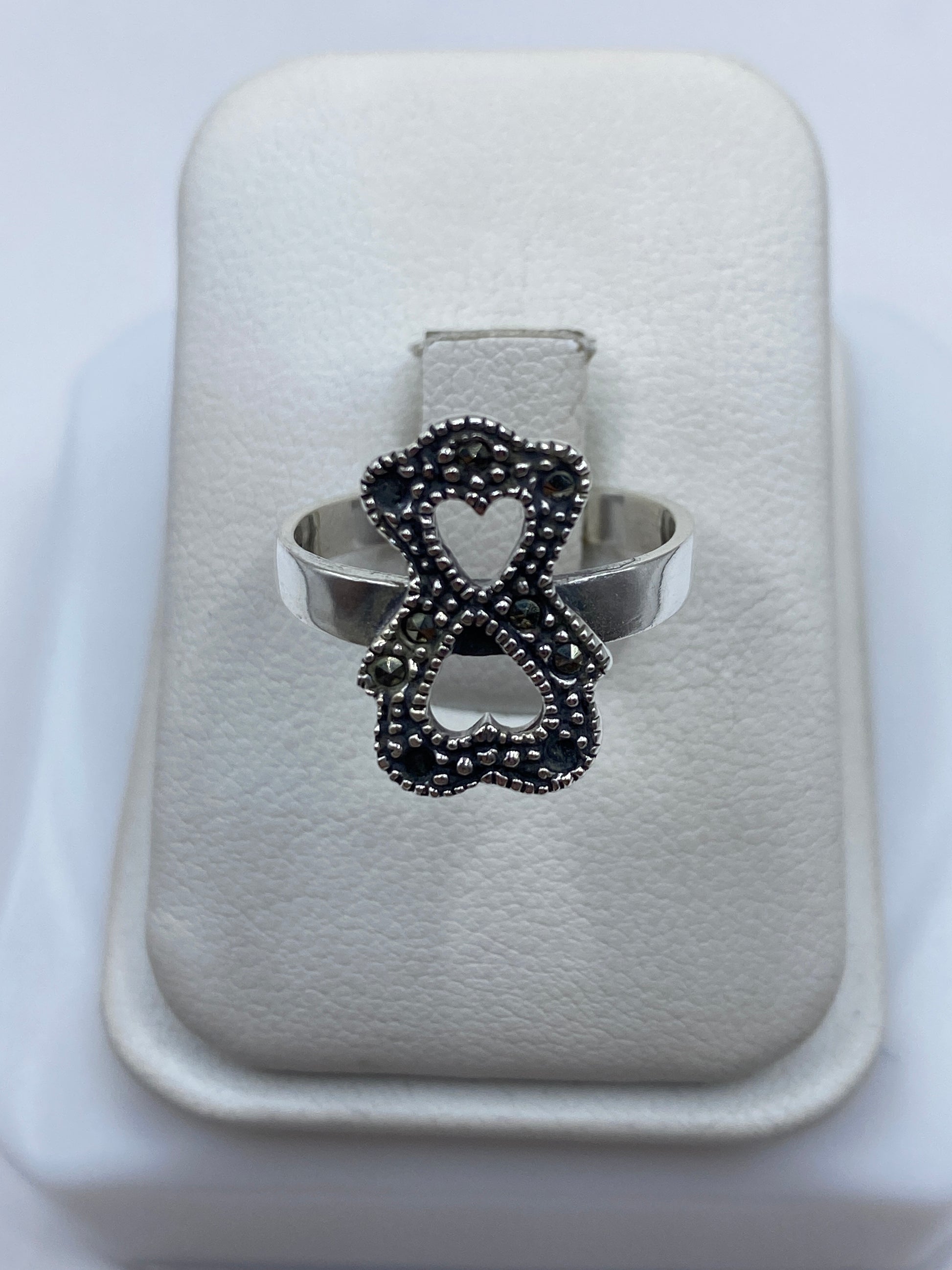 Anillo de plata lazo minimalista con piedra en la mano de una mujer