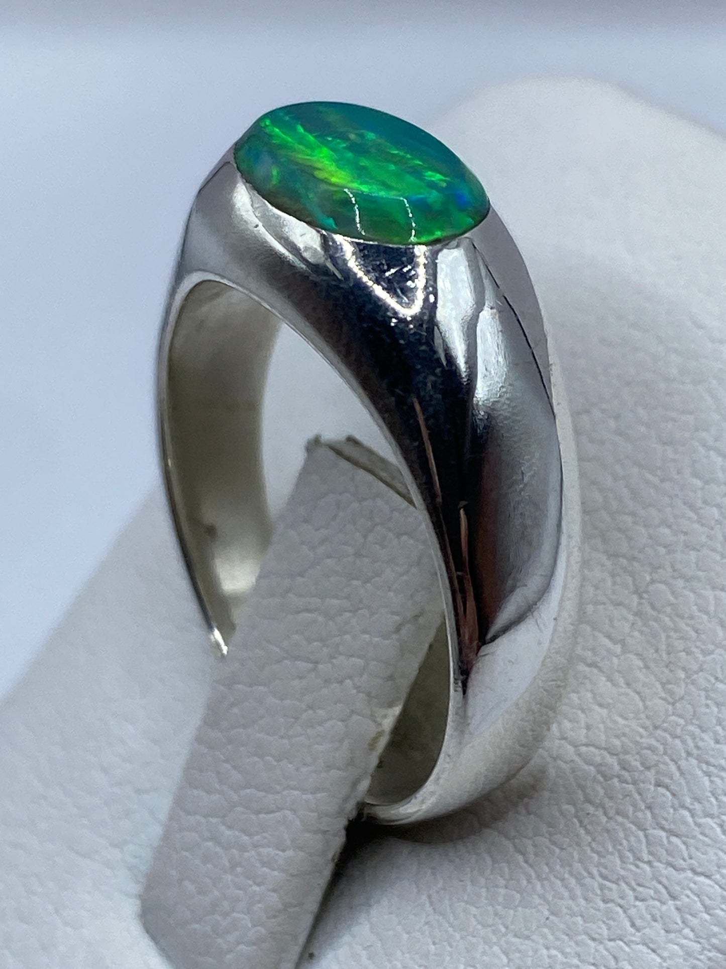 Detalle del ópalo de fuego verde con juego de color azul bajo iluminación directa
