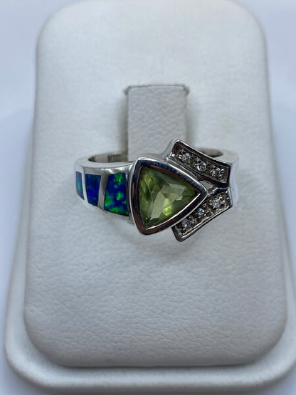 Anillo de plata con ópalo de fuego azul en tonos naturales sobre fondo blanco