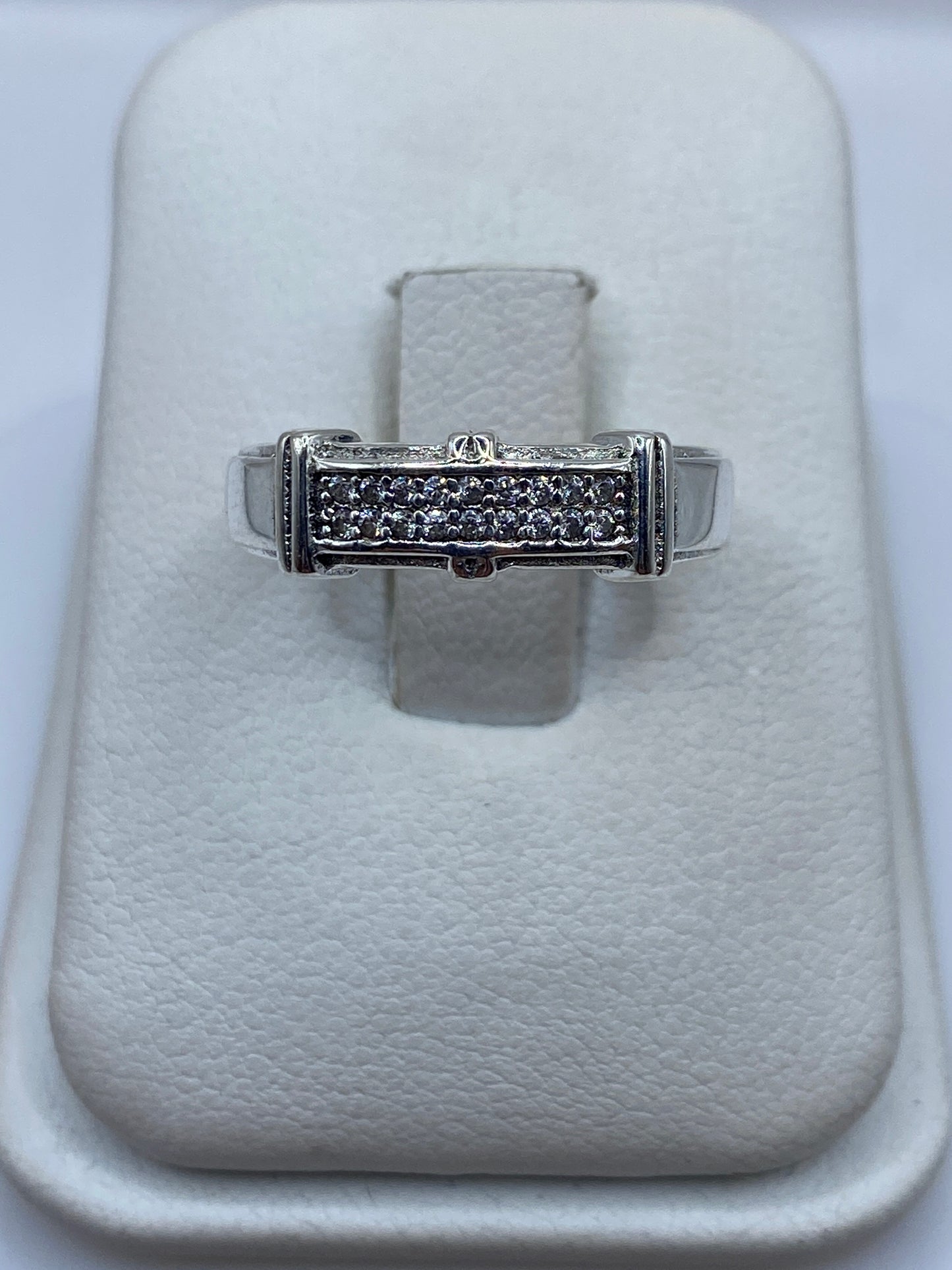 Anillo de plata solitario con circonia blanca sobre almohada de tela blanca