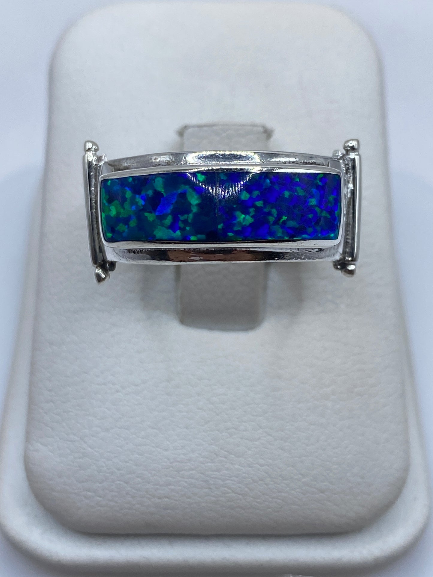 Anillo de plata con ópalo de fuego azul, vista frontal sobre blanco