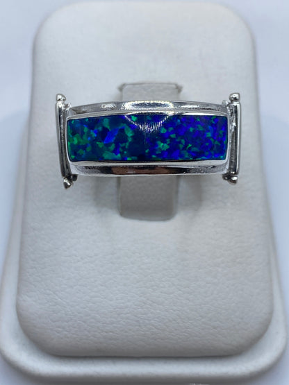 Anillo de plata con ópalo de fuego azul, vista frontal sobre blanco
