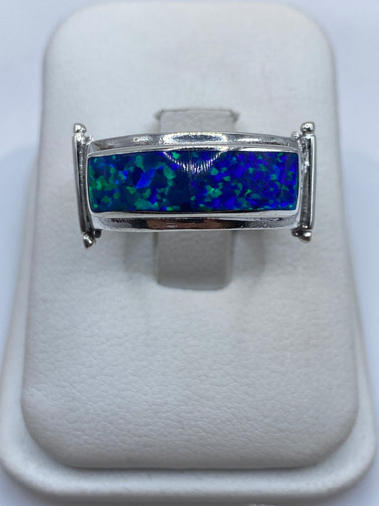 Anillo de plata con ópalo de fuego azul, vista frontal sobre blanco