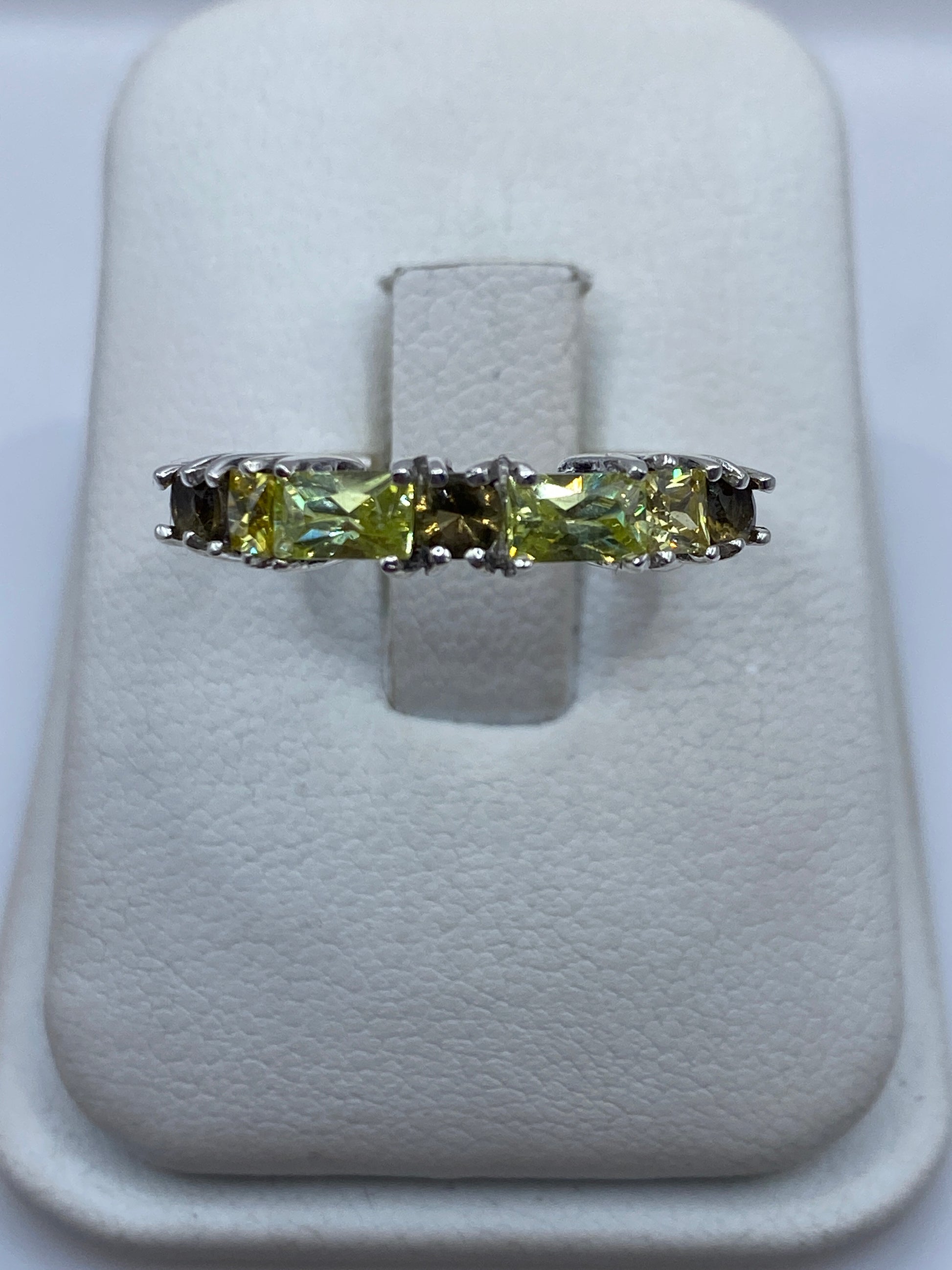 Anillo de plata con circonia amarilla en forma de radiante en la mano de una mujer