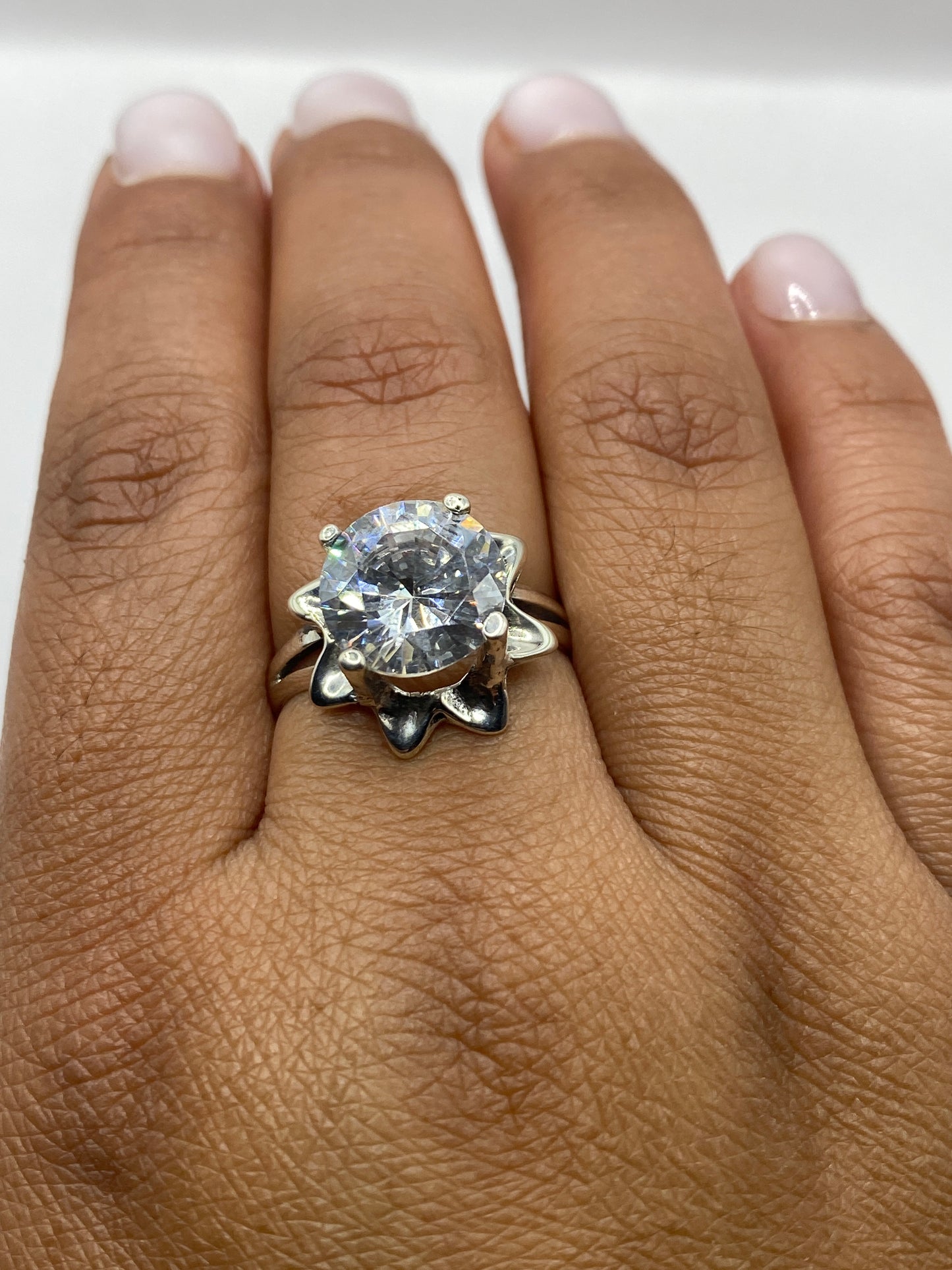 Anillo solitario en dedo mostrando el brillo y fuego de la circonia