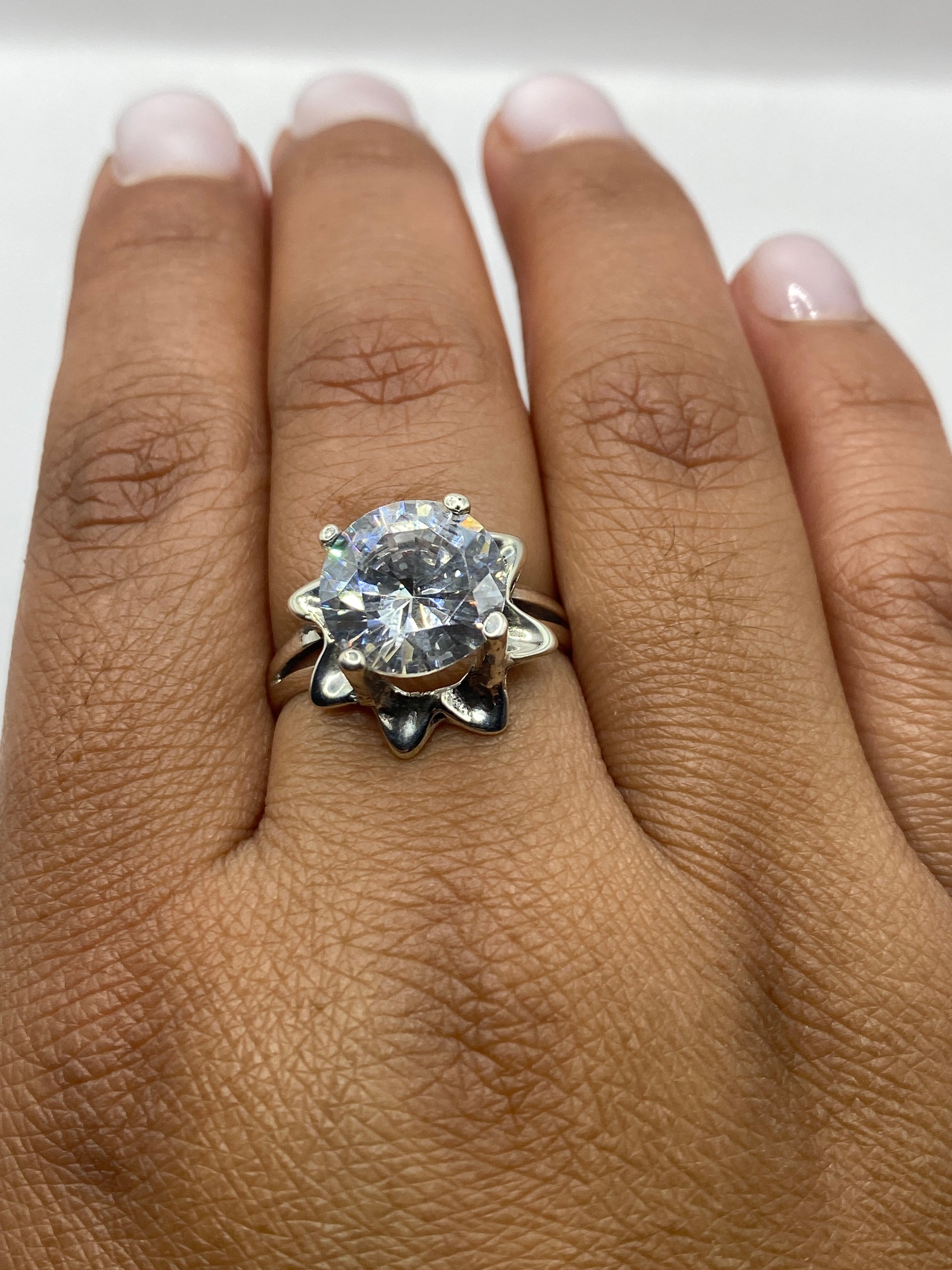 Anillo solitario en dedo mostrando el brillo y fuego de la circonia