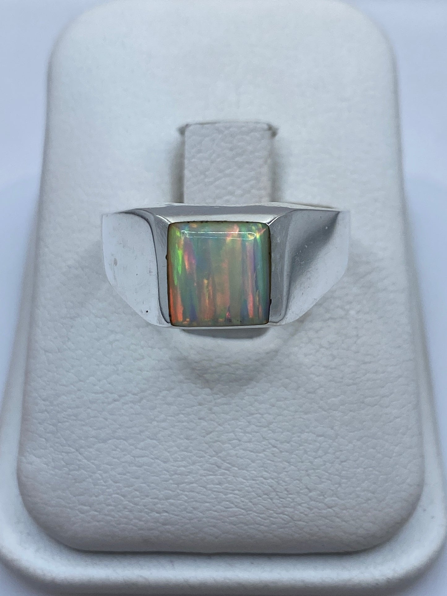 Anillo de plata .950 con ópalo de fuego multicolor en caja blanca, vista frontal del montaje central
