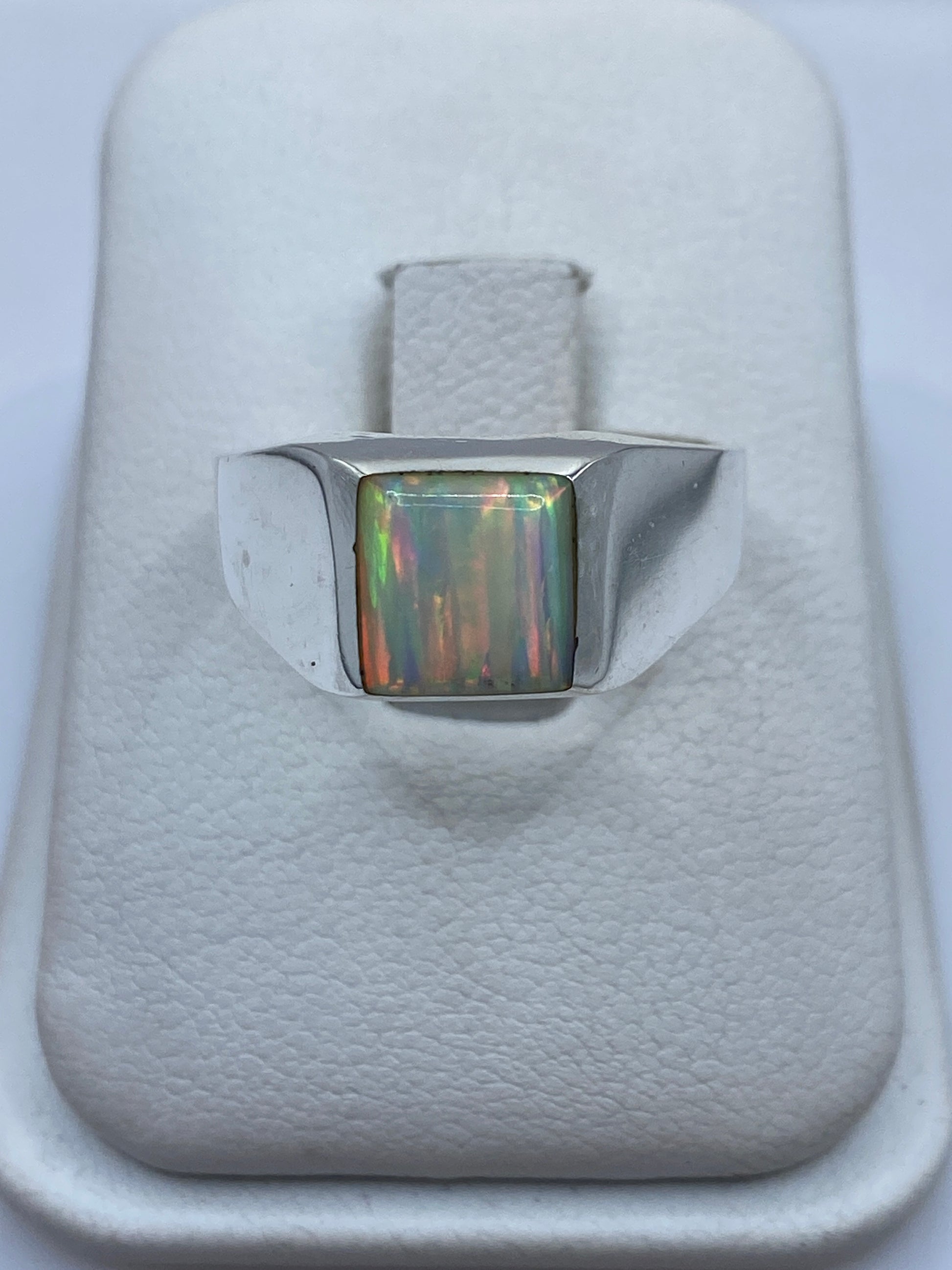 Anillo de plata .950 con ópalo de fuego multicolor en caja blanca, vista frontal del montaje central