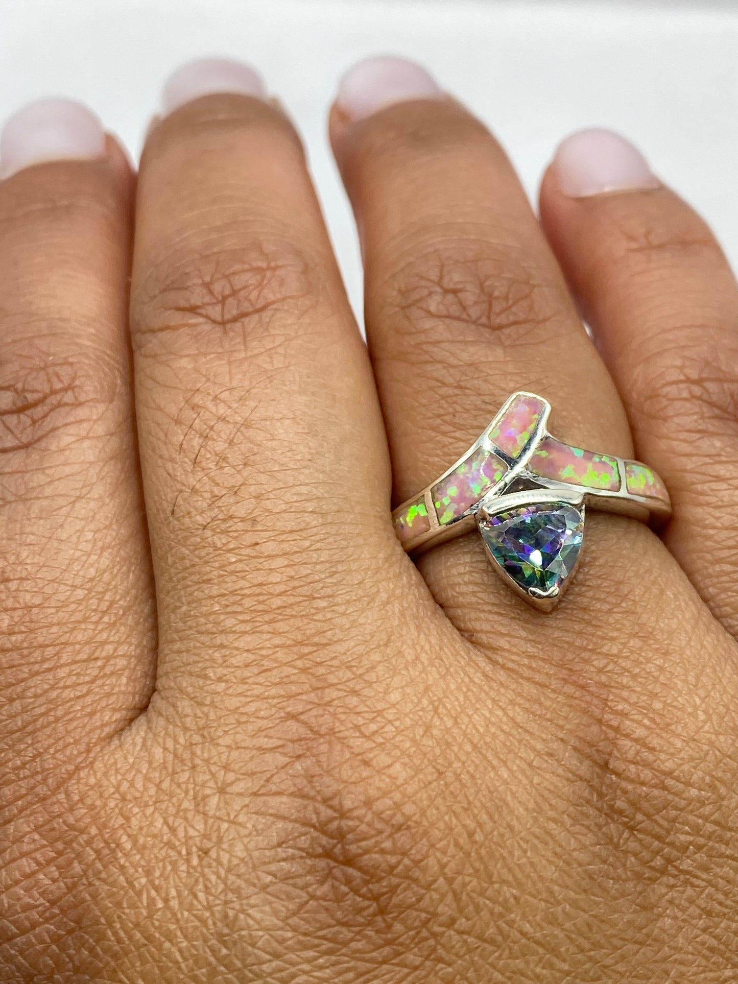 Anillo en la mano mostrando el brillo y los destellos del ópalo de fuego