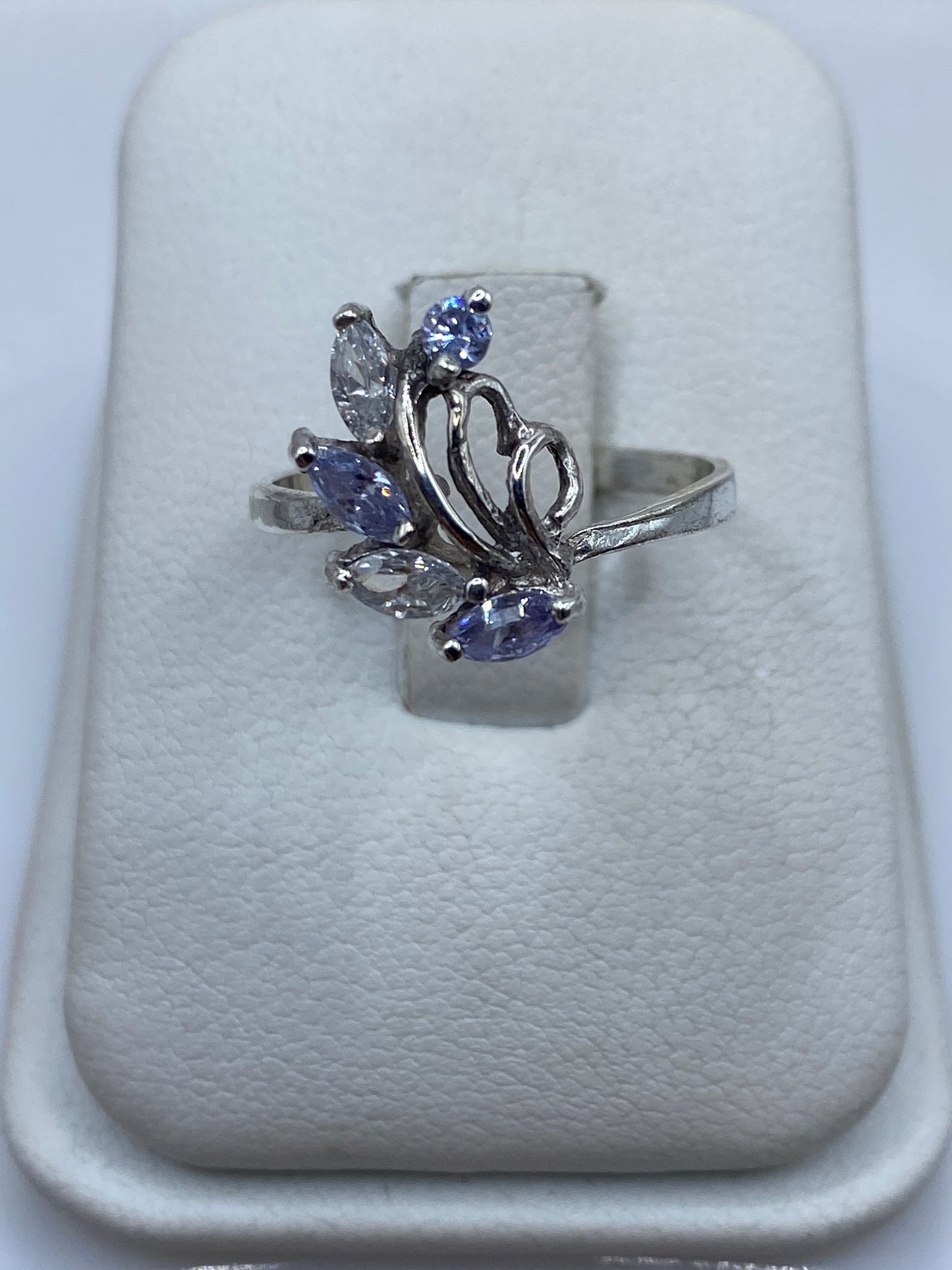 Anillo de plata con circonia azul solitaria en expositor blanco