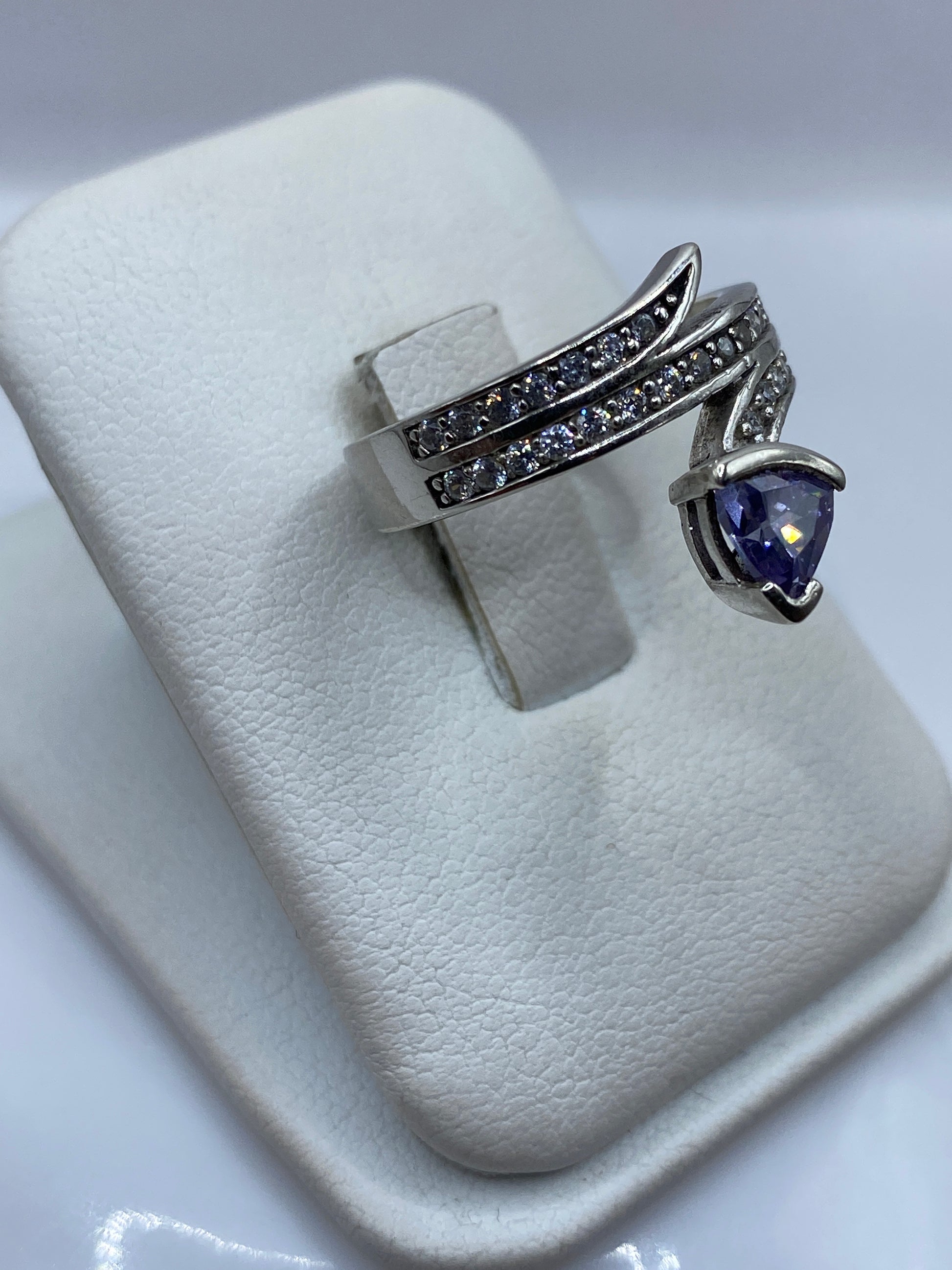 Vista frontal del anillo solitario morado en mano de mujer, detalle del engaste