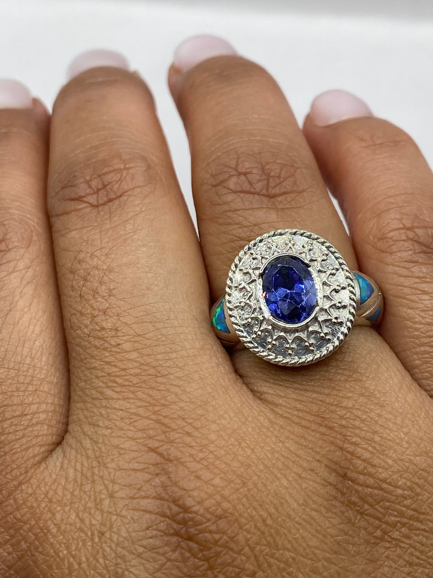 Anillo sobre dedo mostrando el destello azul verdoso del ópalo natural