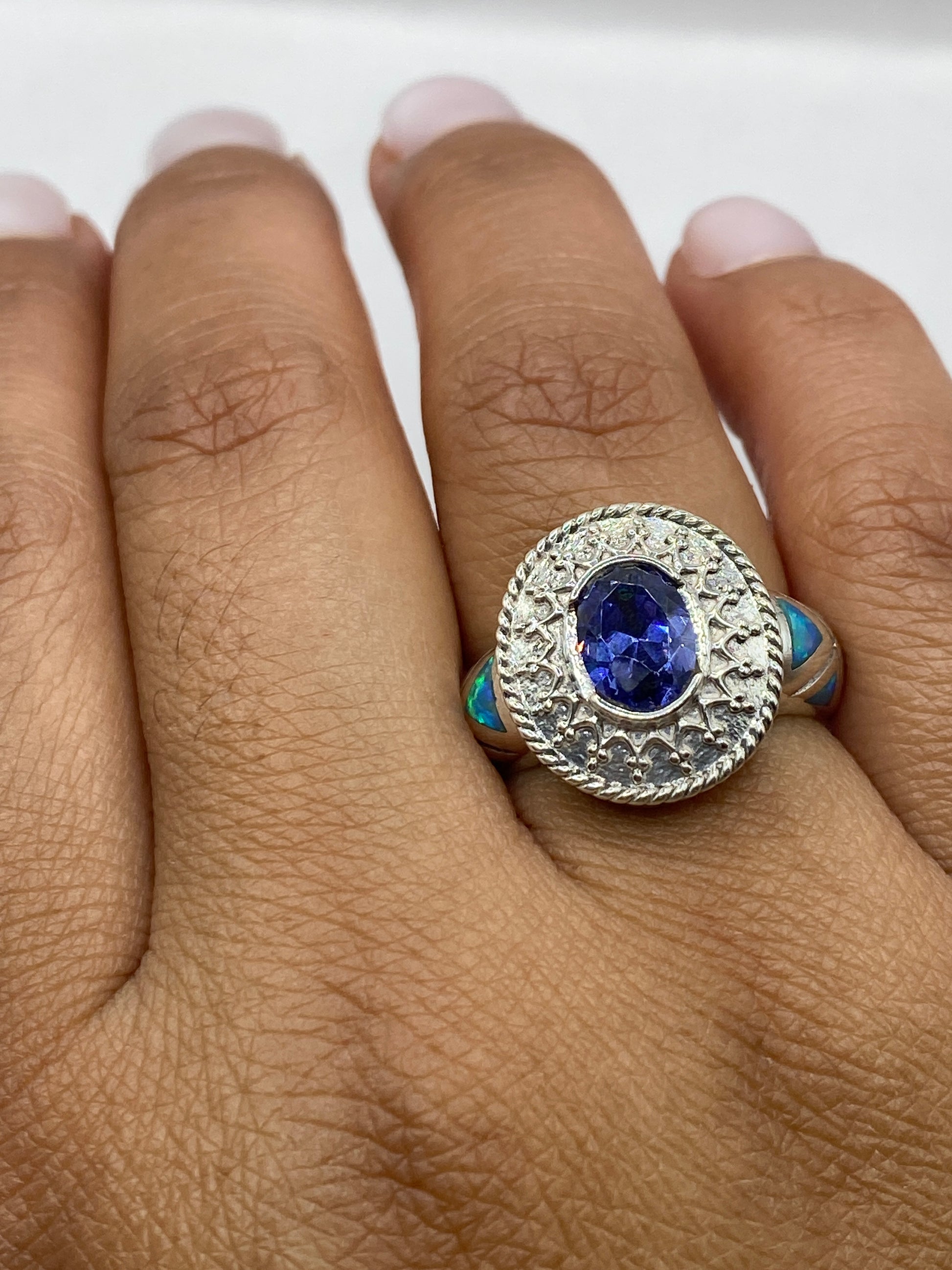 Anillo sobre dedo mostrando el destello azul verdoso del ópalo natural