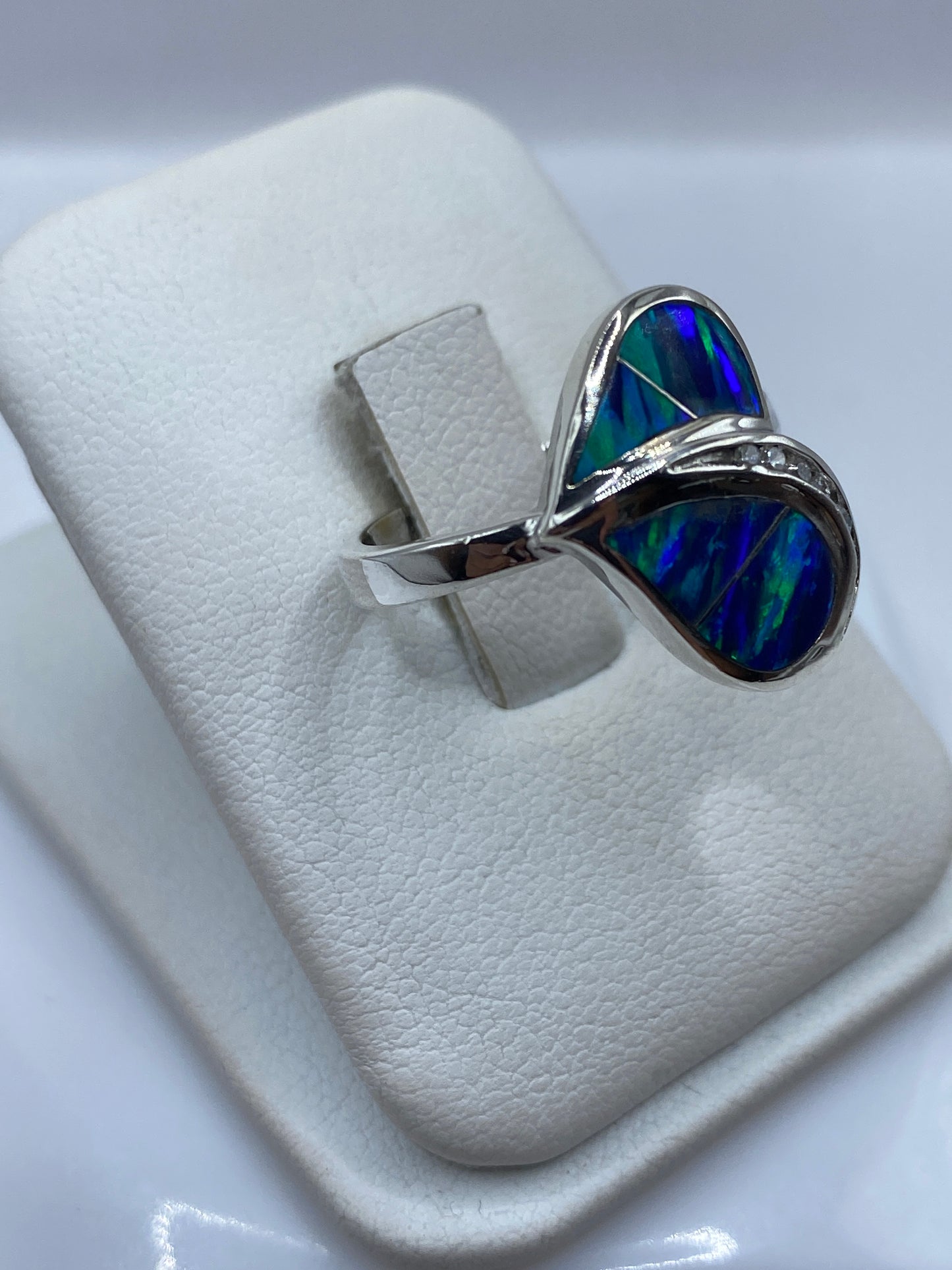 Vista frontal del anillo escultural mostrando el juego de color azul verdoso del ópalo de fuego