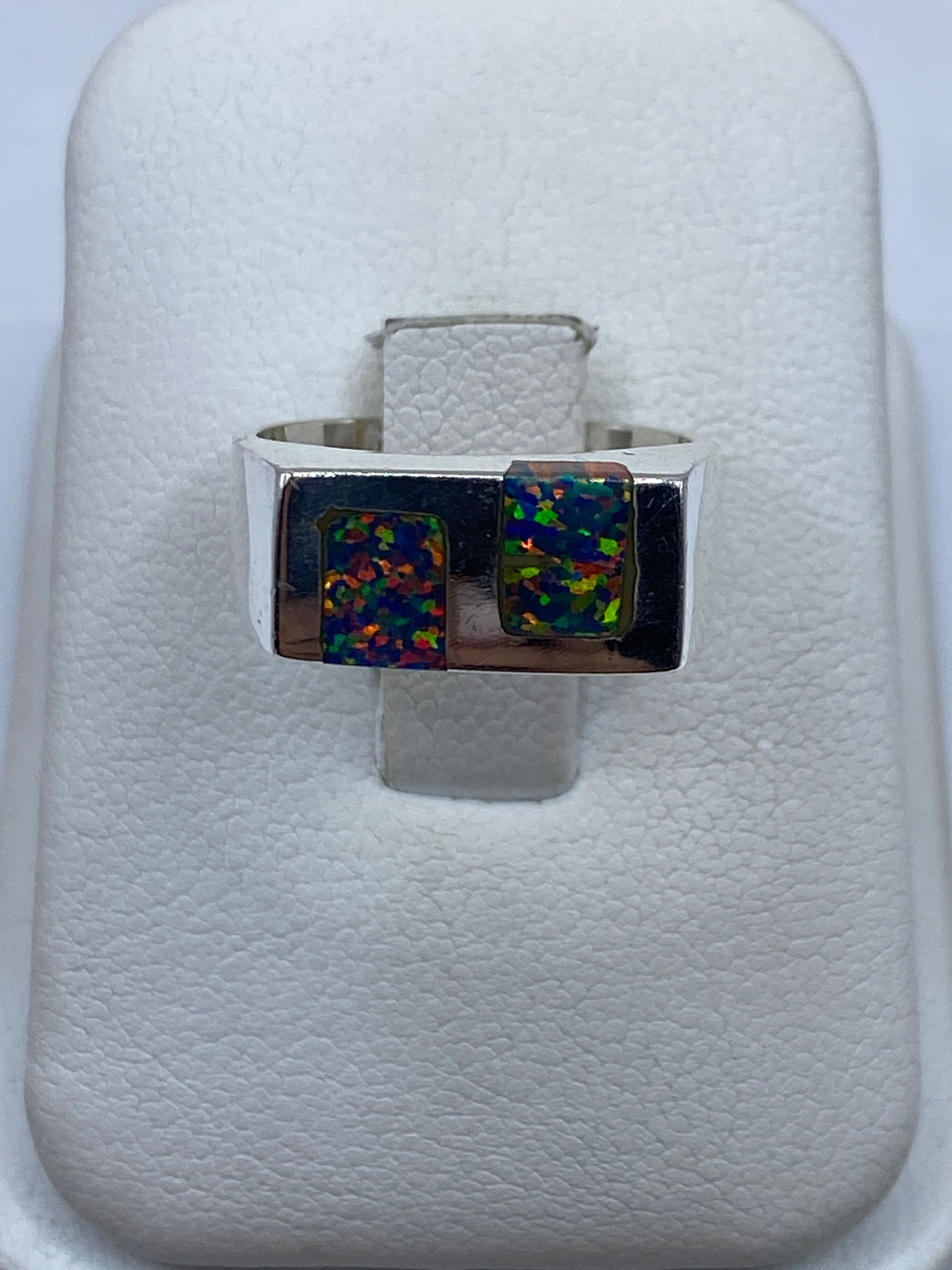 Anillo de plata .950 con ópalo de fuego multicolor mostrando juego de azul, verde y naranja en luz natural