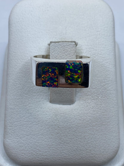 Anillo de plata .950 con ópalo de fuego multicolor mostrando juego de azul, verde y naranja en luz natural
