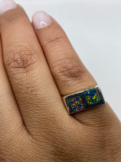 Anillo de plata con ópalo de fuego en dedo, mostrando la paleta multicolor desde ángulo lateral