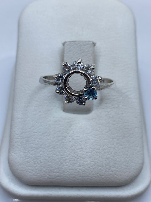 Anillo solitario de plata con circonia blanca brillante sobre almohada blanca